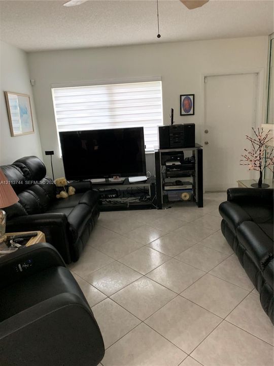 Ceramic tile flooring arranged in a diagonal pattern, horizontal window blinds, and a ceiling fan