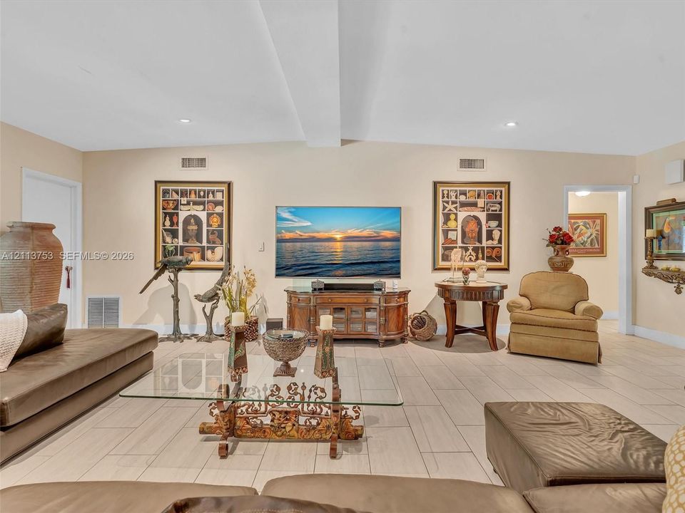 Living area featuring neutral wall tones, large-format tile flooring, and recessed ceiling lighting