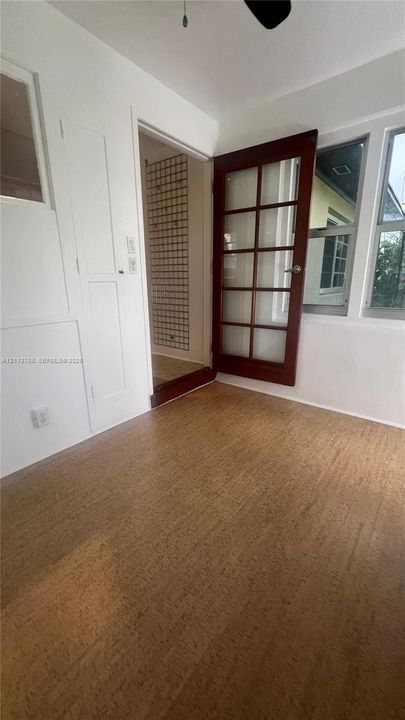 Cork flooring, multi-pane glass door with a wood finish, and built-in cabinetry