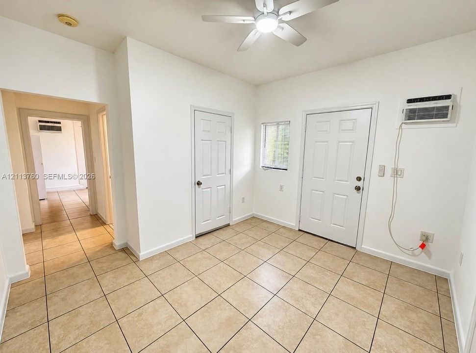 Ceramic tile flooring, white six-panel interior doors, and a ceiling fan with integrated lighting
