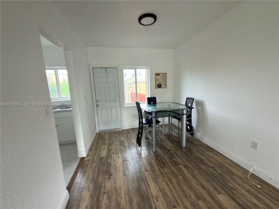 Wood-finish flooring, white walls, flush-mount ceiling lighting, and windows providing natural light