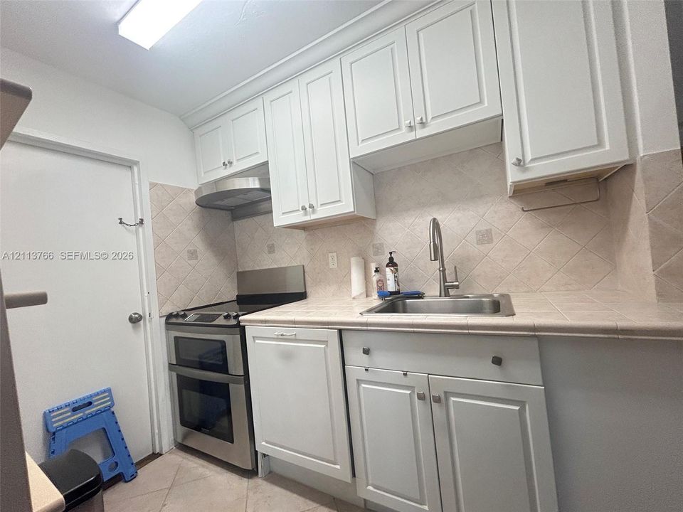 Large-format windows, light-toned ceramic tile flooring, and neutral wall finishes