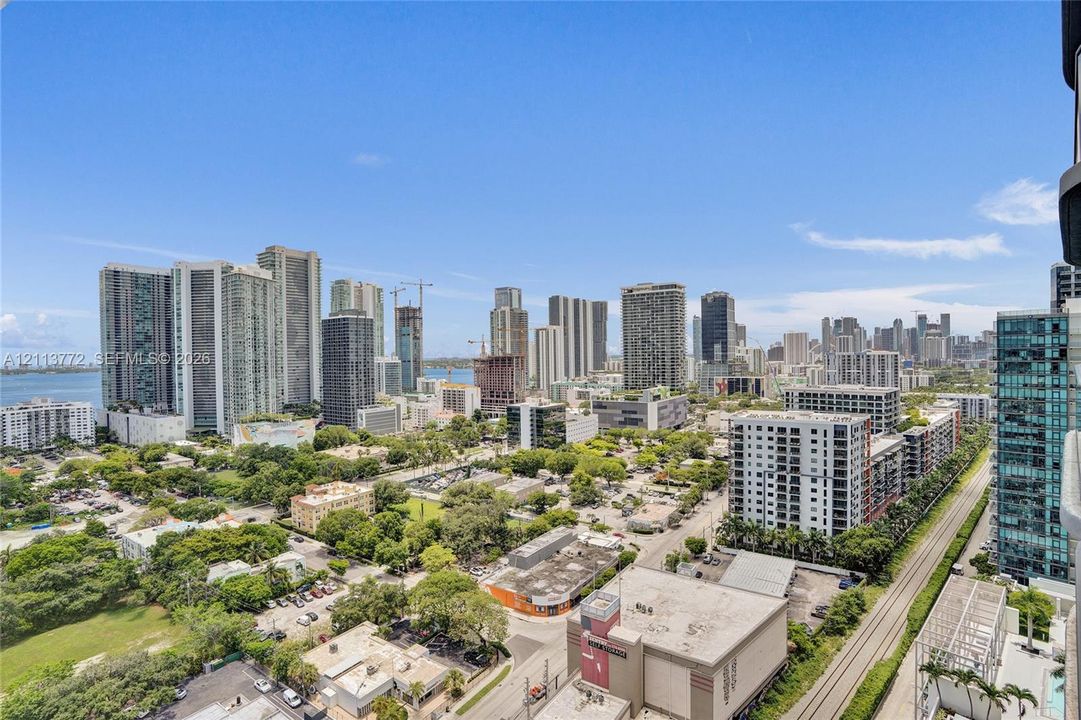 Panoramic cityscape featuring high-rise buildings, urban infrastructure, and coastal waterfront scenery