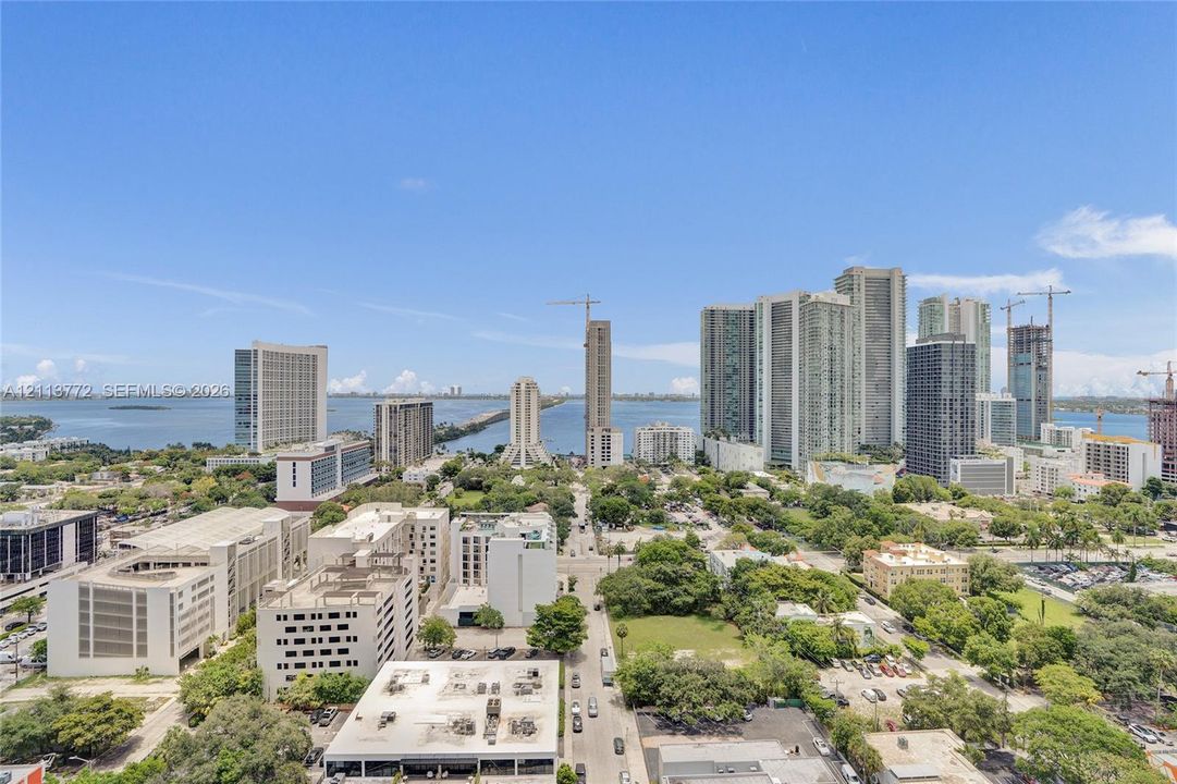 Elevated urban perspective featuring panoramic city skyline, waterfront horizon, and expansive metropolitan landscape
