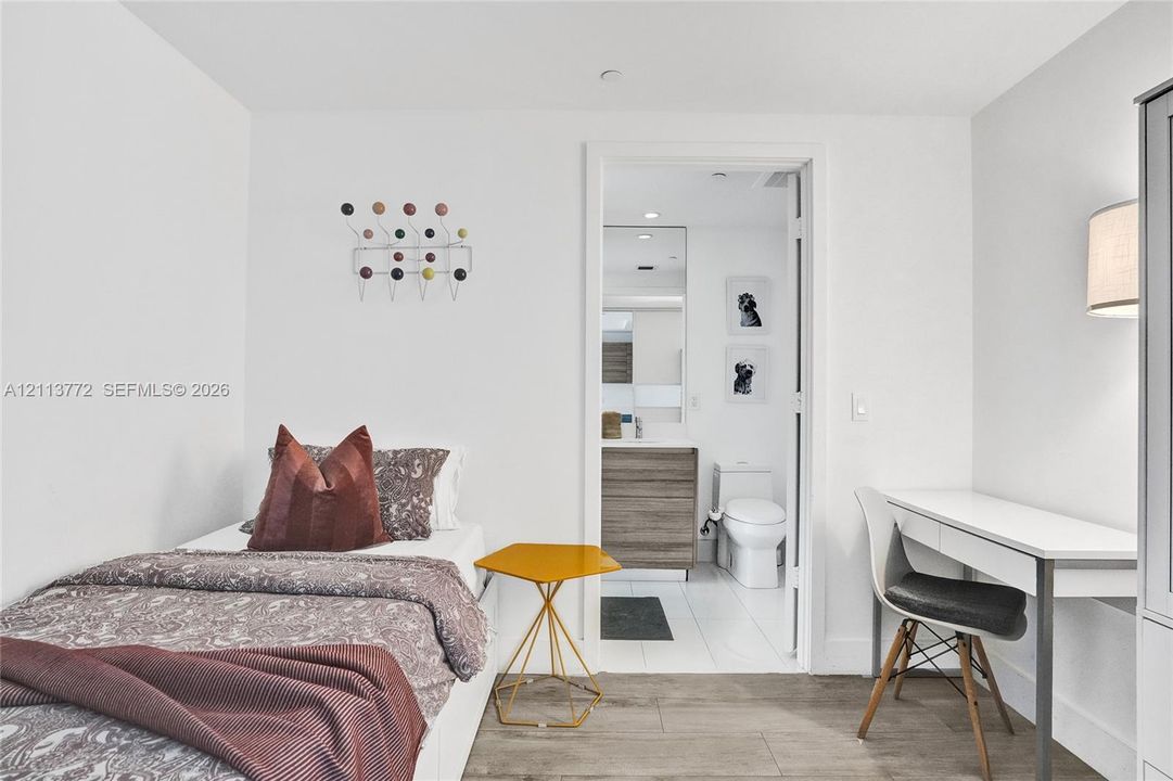 Wood-finish flooring, attached wall-mounted coat rack, and white interior finish