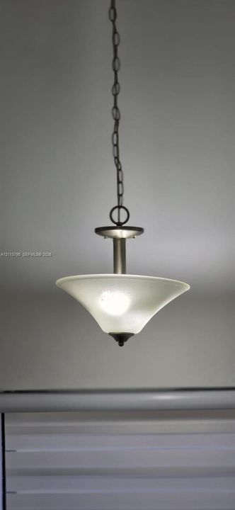 Brushed nickel pendant light fixture featuring a chain-link suspension and a flared, frosted glass shade