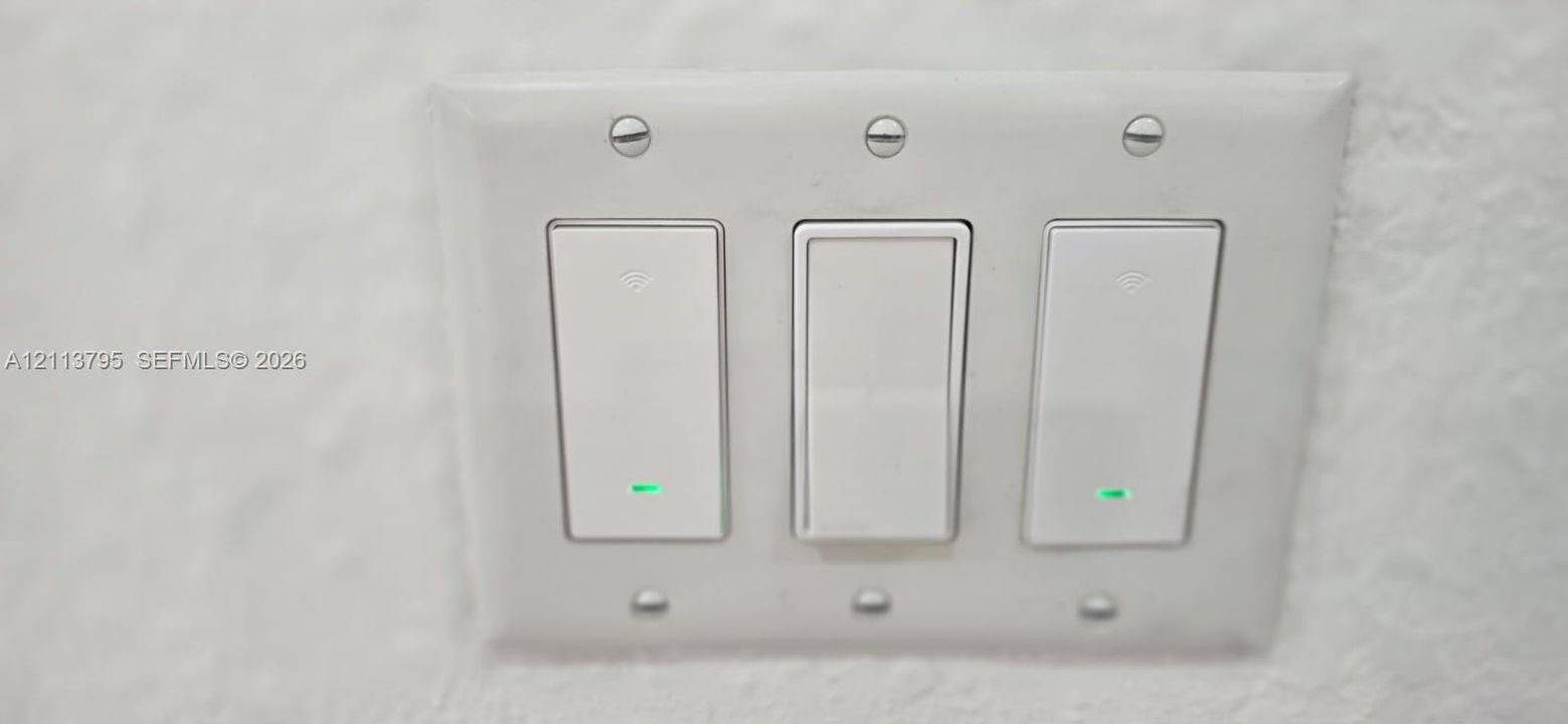 Triple-gang electrical switch plate featuring white rocker-style switches with integrated status indicators