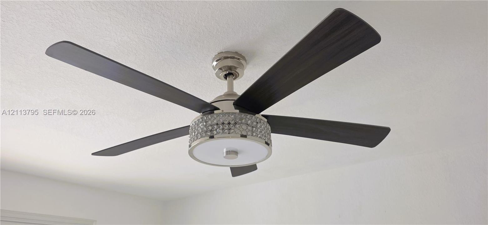 Ceiling fan featuring a brushed nickel finish, four dark wood-finish blades, and a circular drum light fixture accented with faceted crystal detailing
