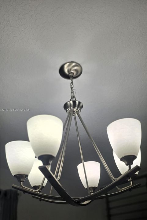Five-light chandelier featuring a brushed-nickel finish and textured glass shades
