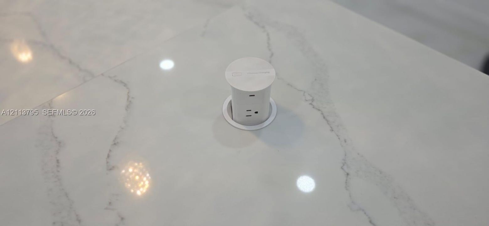 Engineered stone countertop featuring a retractable, built-in electrical pop-up power outlet