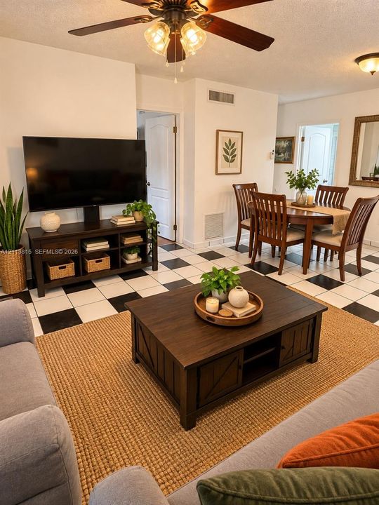 Checkered tile flooring featuring a high-contrast pattern, ceiling fan with glass globe light fixtures, and multi-panel interior doors