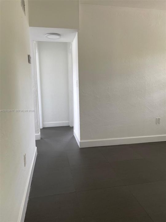 Neutral-toned walls paired with large-format tile flooring and recessed overhead lighting
