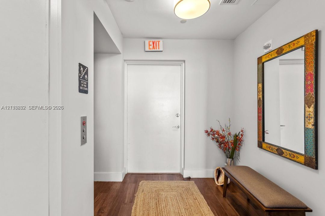 Entryway featuring wood-finish flooring, a flush-mount ceiling light fixture, and a solid-panel door