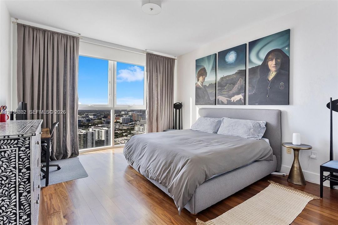 Floor-to-ceiling windows, wood-finish flooring, and recessed ceiling lighting