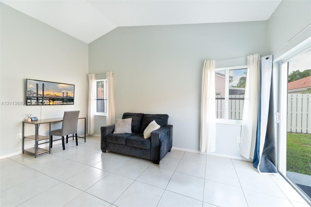 Vaulted ceilings, large-format tile flooring, and sliding glass patio doors