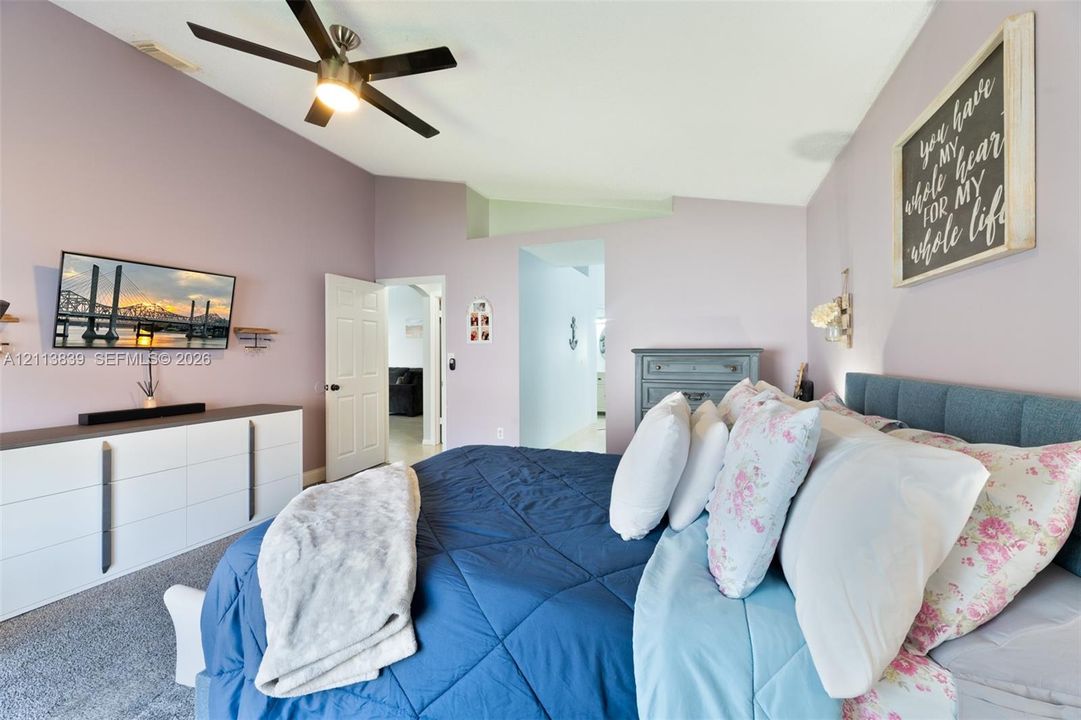 Vaulted ceiling with an integrated multi-blade ceiling fan and wall-to-wall carpeting