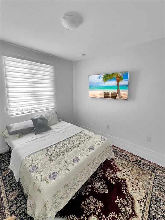 Neutral-toned room featuring high-contrast window treatments and flush-mount ceiling lighting