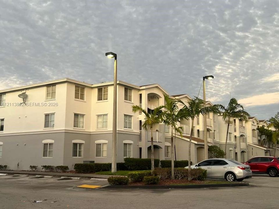 Multi-story exterior featuring a two-tone stucco facade, arched architectural detailing, and integrated balconies