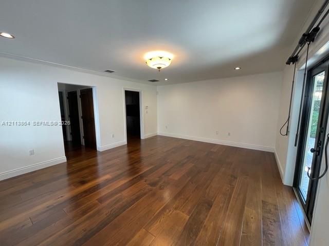 Wide-plank wood-finish flooring, recessed ceiling lighting, decorative flush-mount light fixture, and black-framed glass sliding doors