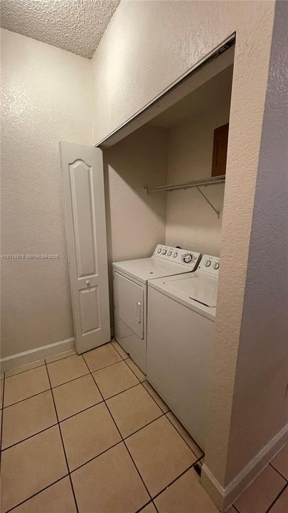Utility area featuring tiled flooring, a recessed closet space, and built-in wire shelving