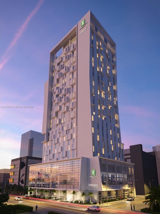 High-rise commercial structure featuring a contemporary white facade, rhythmic modular fenestration, floor-to-ceiling glass paneling at the podium level, and recessed upper-level terrace