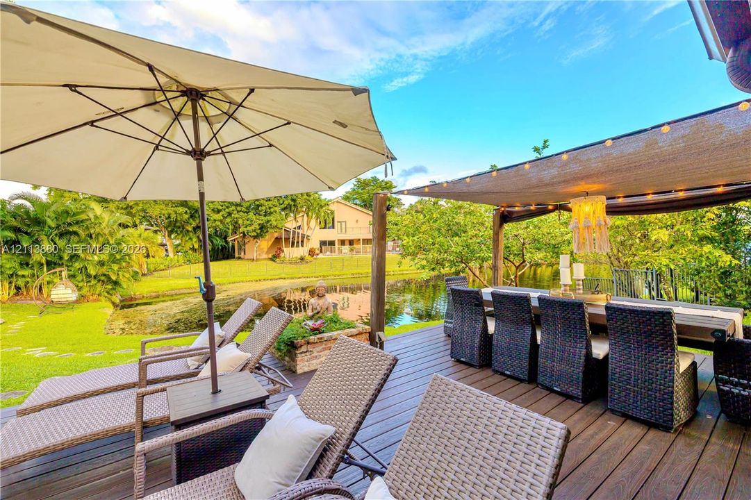 Wood-plank deck featuring a fabric shade canopy and water frontage