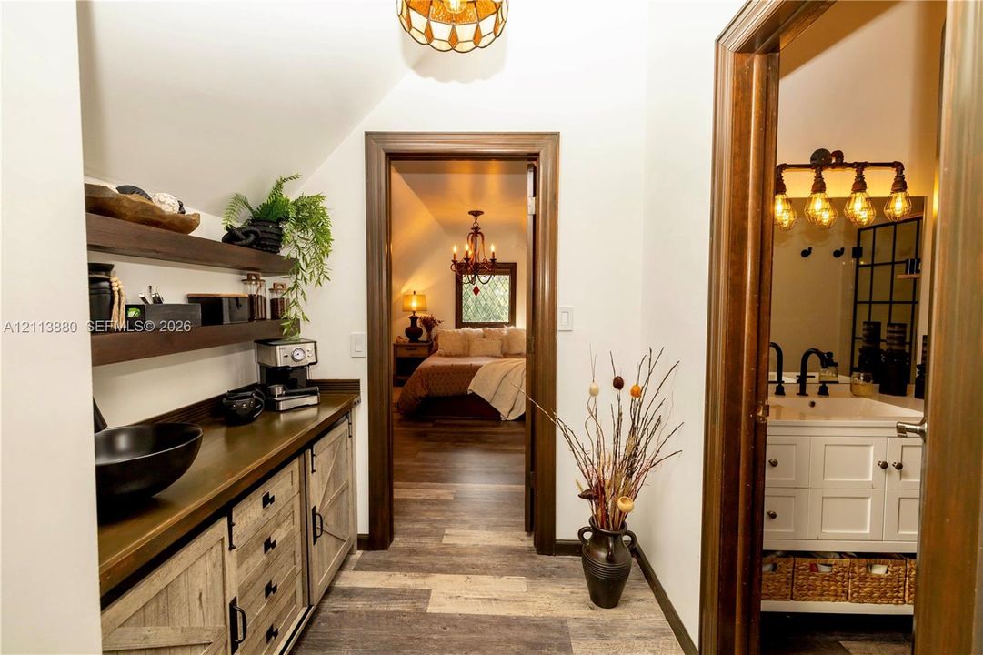 Built-in cabinetry featuring wood-finish lower cabinets with barn-style doors and dark-toned open shelving