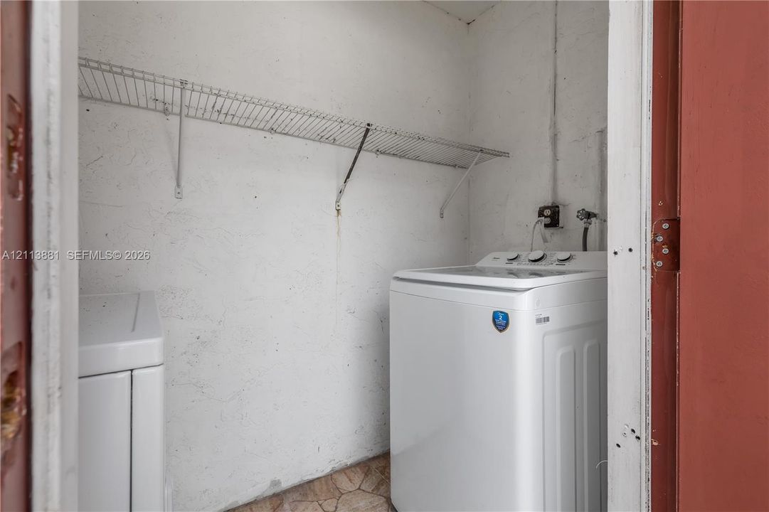 Laundry space featuring wall-mounted wire shelving and dedicated water hookups