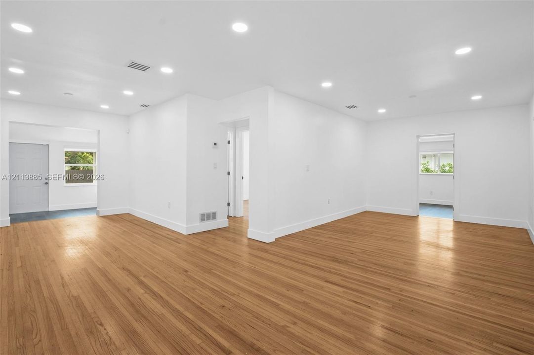 Open-concept interior featuring wood-finish flooring, recessed lighting, and white walls