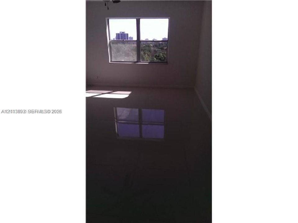 Interior space featuring large-format tile flooring and a double-pane window with a frame-integrated muntin