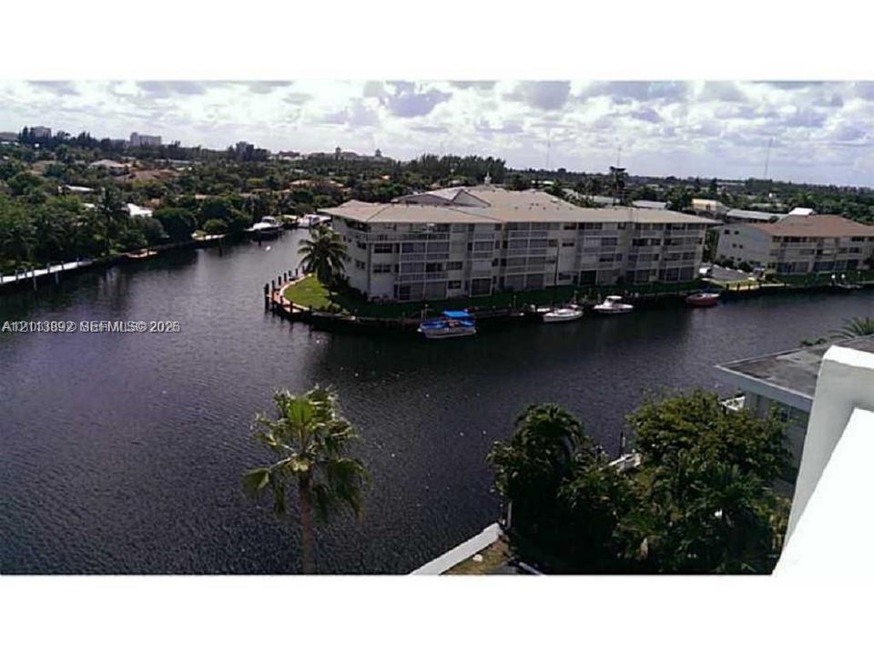 Waterfront multi-story residential building featuring balconies, canal access, and dockage