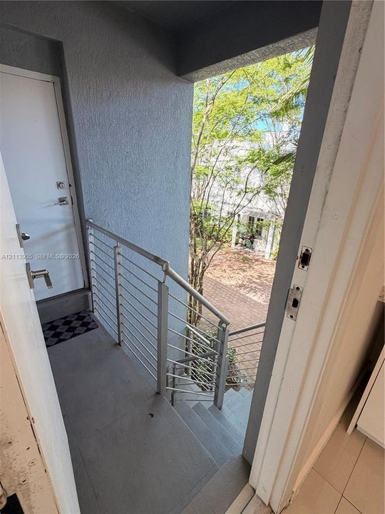 Exterior staircase featuring concrete steps and horizontal metal cable railing