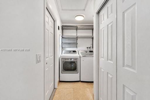 Laundry room featuring tile flooring, white panel doors, metal wire shelving, and overhead flush-mount lighting