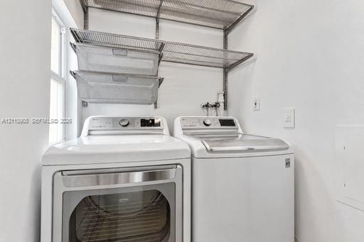 Laundry area featuring wall-mounted wire shelving, two pull-out metal storage baskets, and high-capacity laundry appliances
