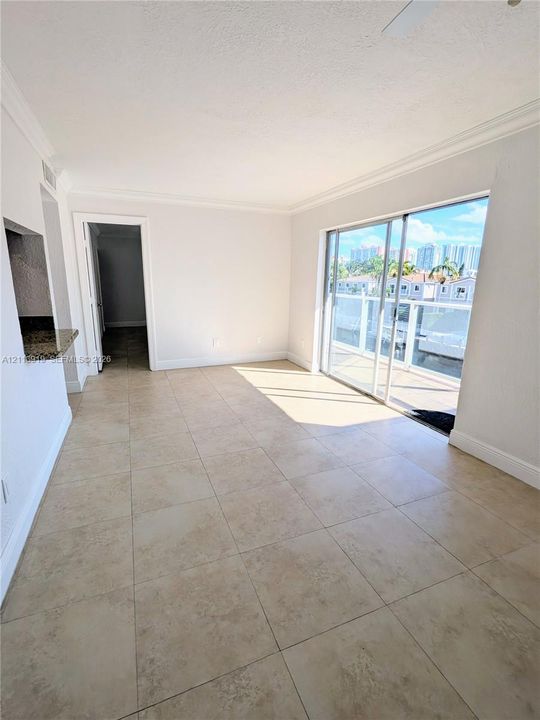 Neutral tile flooring, sliding glass doors, and built-in counter space with a stone-surface finish
