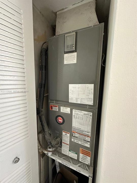 Wall-mounted HVAC air handler unit featuring a neutral-tone finish and integrated digital control interface