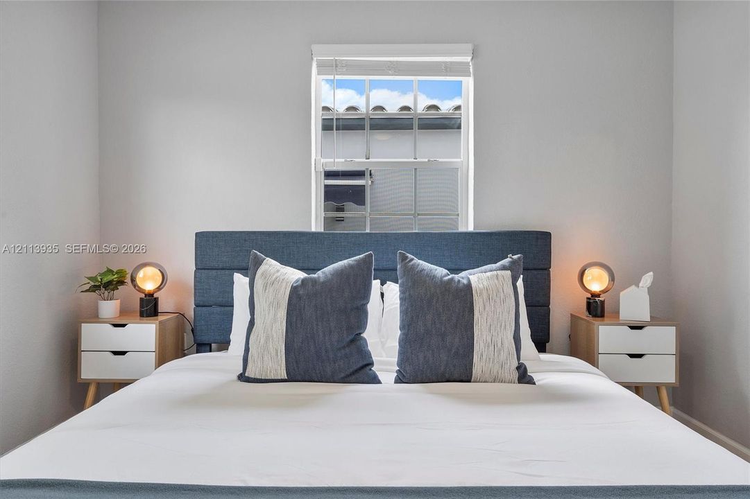 Neutral interior space featuring a single-hung window with white-finish trim and horizontal blinds