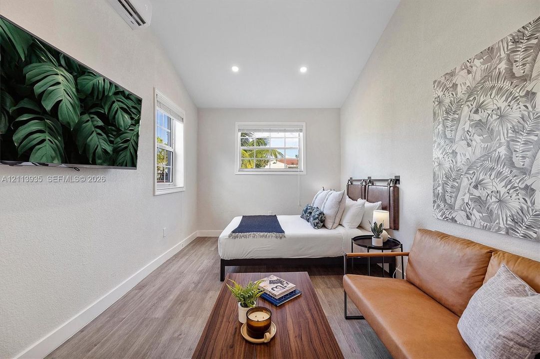 Vaulted ceilings featuring recessed lighting, wood-finish flooring, and dual windows