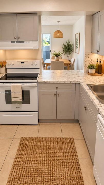 Kitchen featuring grey shaker-style cabinetry, white appliances, stone-patterned countertops, and tile flooring