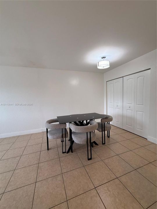 Ceramic tile flooring, double-panel closet doors, and drum-style ceiling light fixture