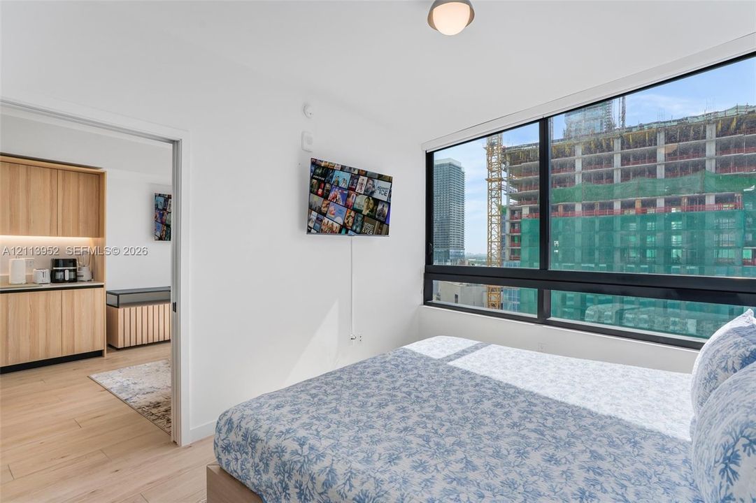 Floor-to-ceiling windows, wood-finish flooring, and recessed ceiling lighting