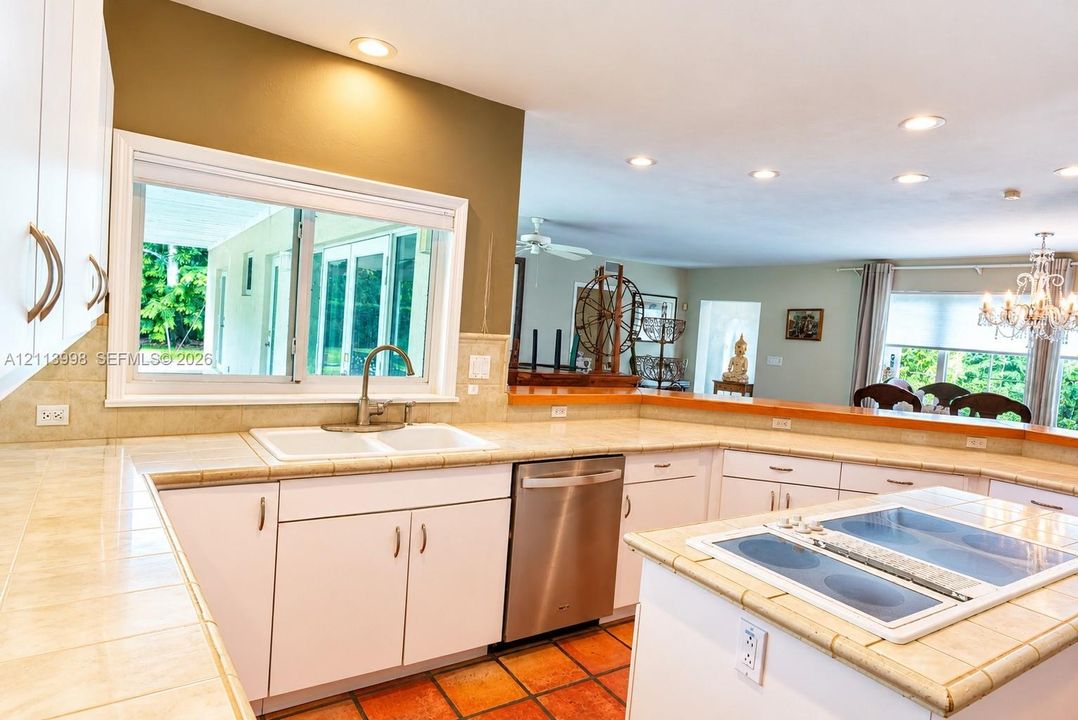 Kitchen featuring white cabinetry, tile countertops, recessed lighting, a stainless steel dishwasher, and a built-in cooktop