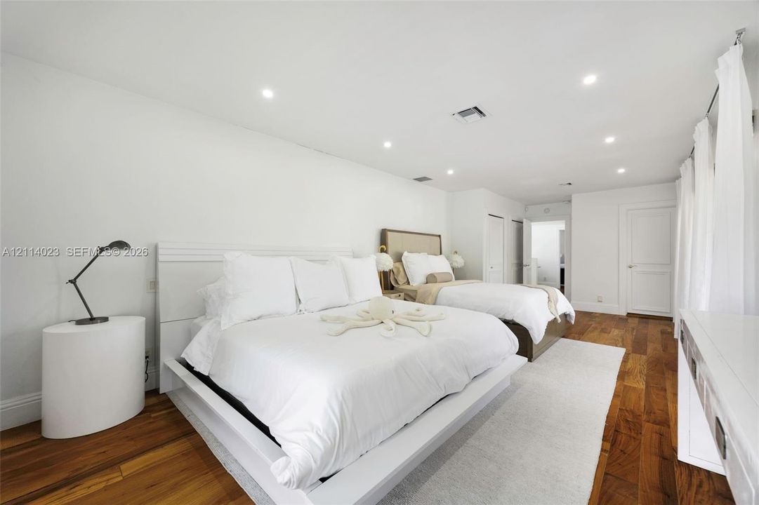 Spacious bedroom featuring wood-finish flooring, recessed lighting, and multi-panel interior doors