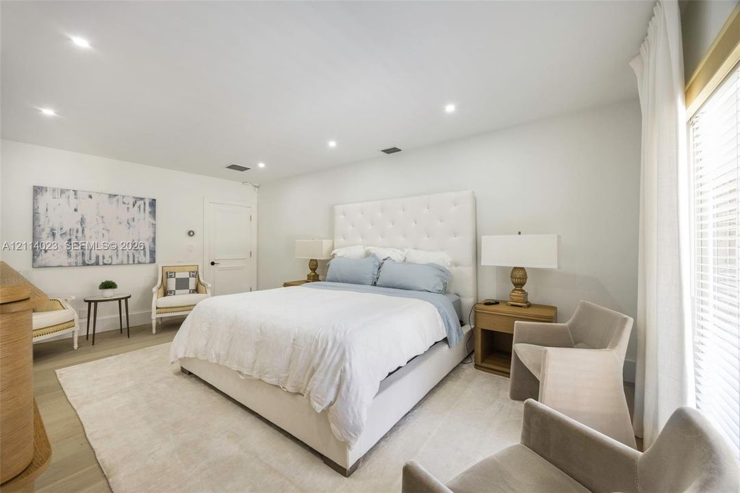 Neutral color palette featuring recessed lighting, wood-finish flooring, and large window with horizontal blinds