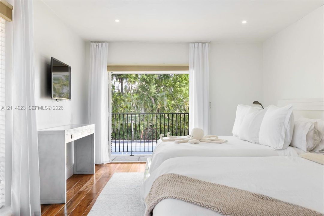 Bedroom featuring wood-finish flooring, recessed lighting, and a private balcony with black metal railing