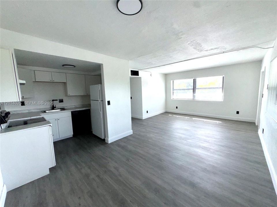 Kitchen featuring white cabinetry, wood-finish flooring, and a large window