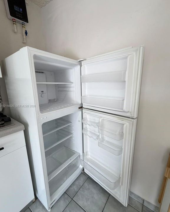 Top-mount white refrigerator featuring adjustable interior shelving, door storage compartments, and crisper drawers