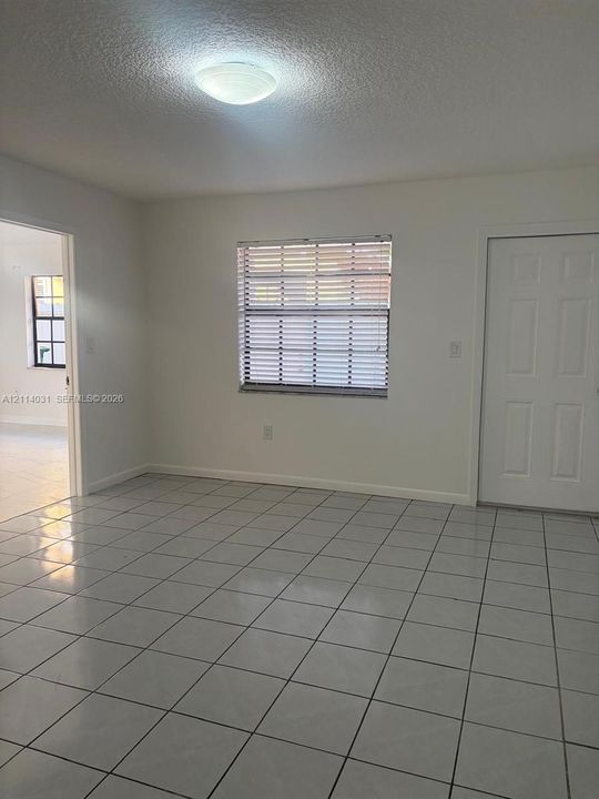 Ceramic tile flooring, neutral wall finishes, flush-mount ceiling lighting, and a six-panel interior door
