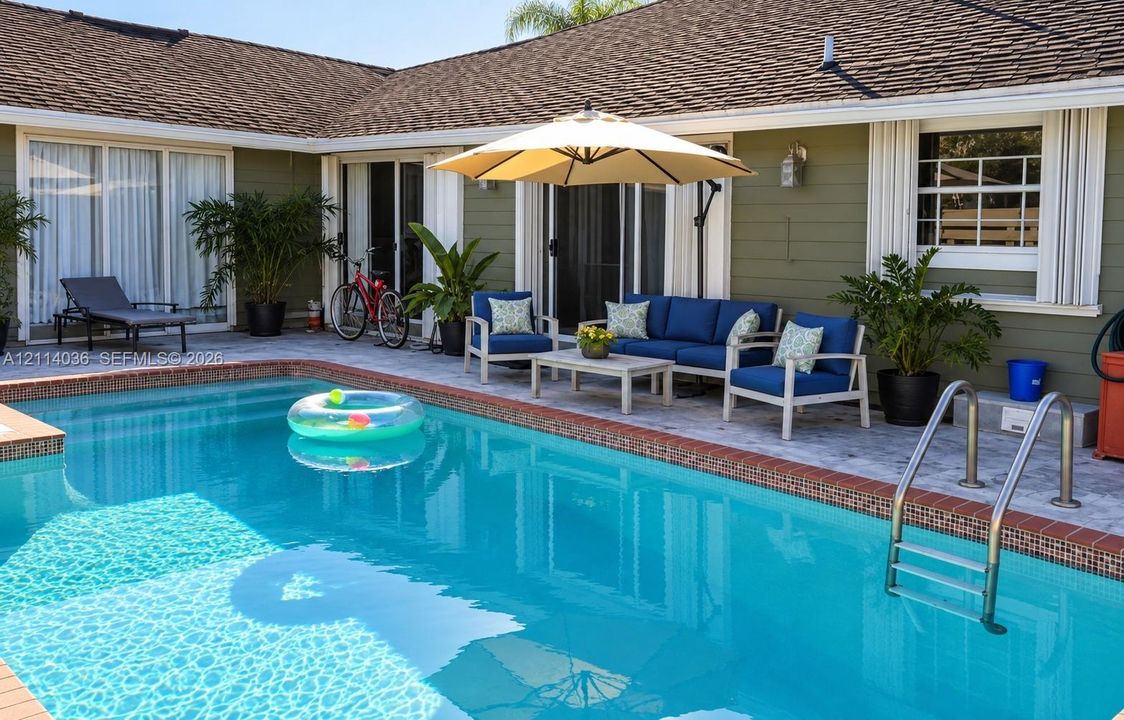 In-ground swimming pool with brick coping, shingle-roof exterior, horizontal lap siding, and stone-paver patio area