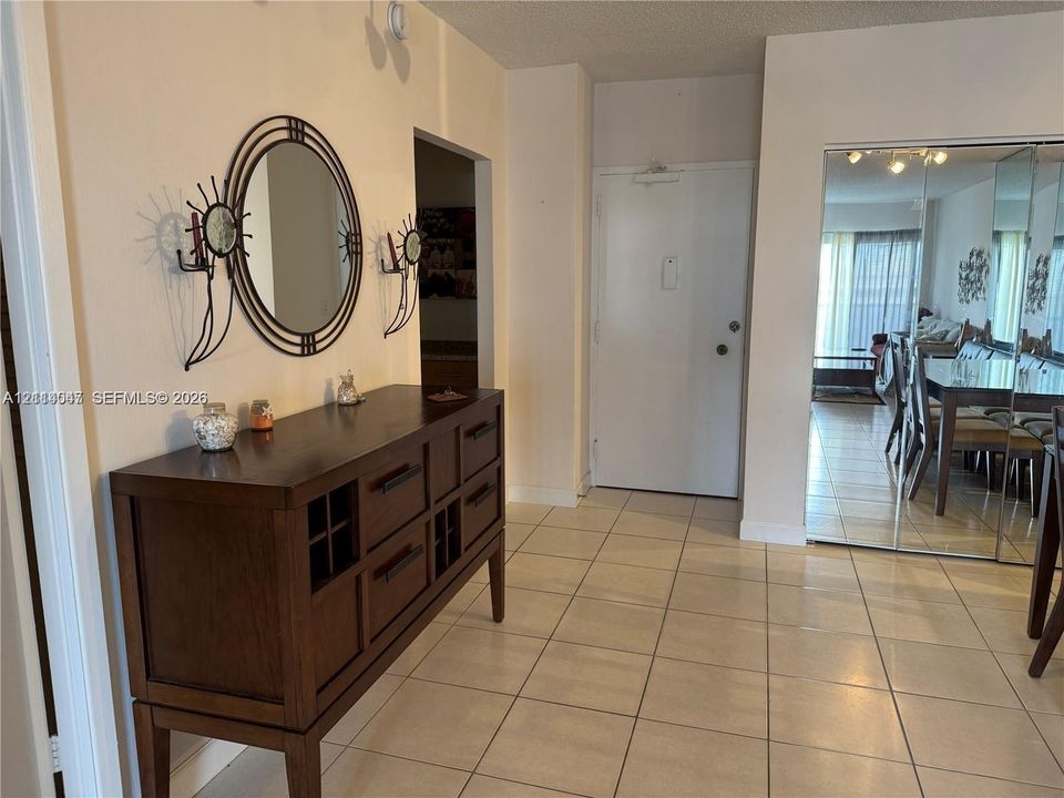 Tile flooring throughout with floor-to-ceiling mirrored closet doors
